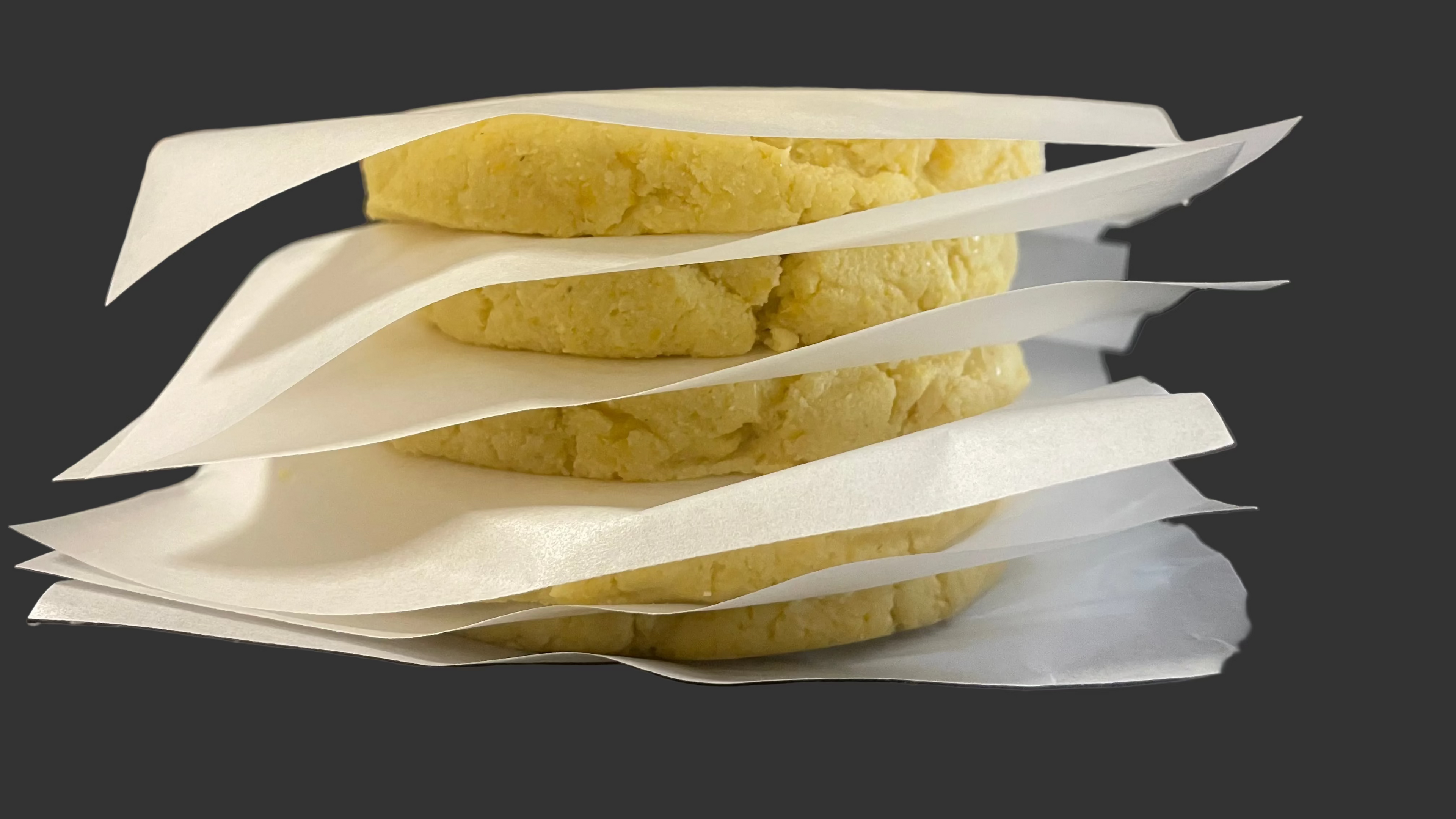 Chocolo Arepa (Stacked): Sweet Corn Arepas stacked in packs of five with parchment paper sheets for easy handling.  Ready to freeze and enjoy whenever you like.
