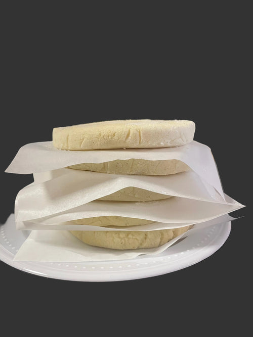 Classic Arepas stacked in packs of five with parchment paper sheets.