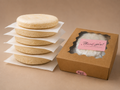 Five Classic White Corn arepas beside The Daily Arepa box.
